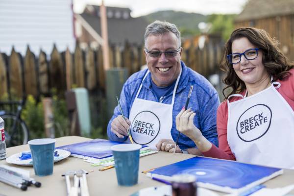 A couple participating in a Breck Create date-night painting class