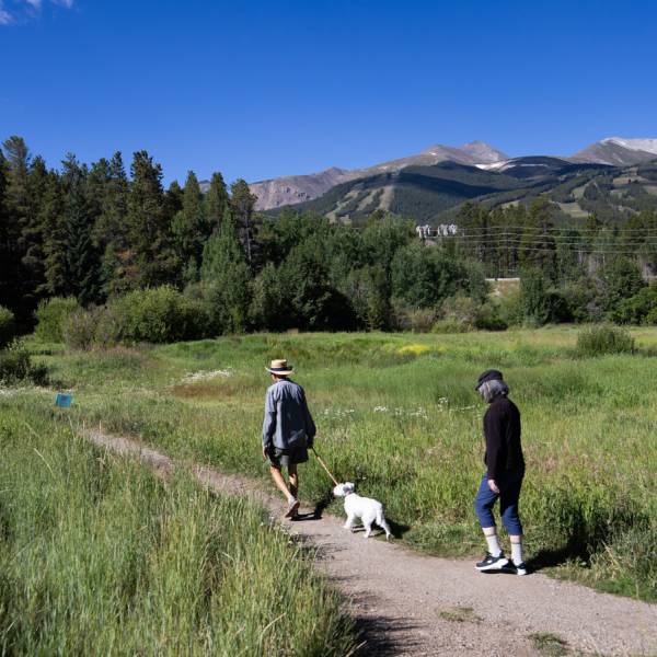 A couple and their dog hiking on a trail in Breckenridge