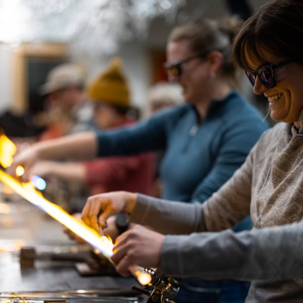 Students in a beginner glassblowing class