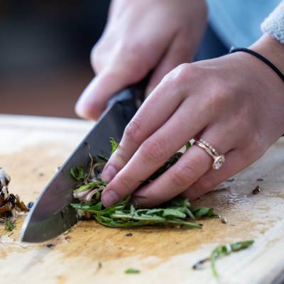 Foraged items are chopped and prepared during a Breck Create Wild Foods class