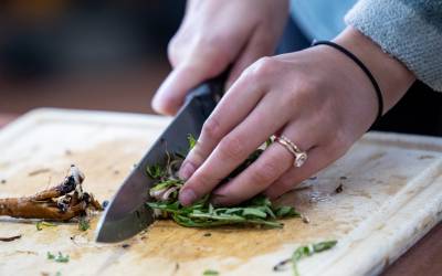 Foraged items are chopped and prepared during a Breck Create Wild Foods class