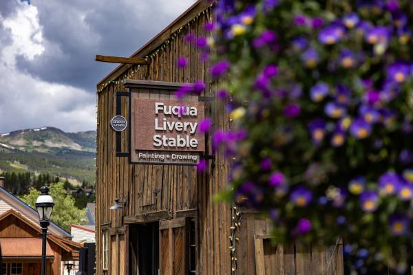 Fuqua Livery Stable is show against the backdrop of the Tenmile Mountain Range - Fuqua is a historic structure on the Breckenridge arts district campus that houses the Precious Plastic workspace.