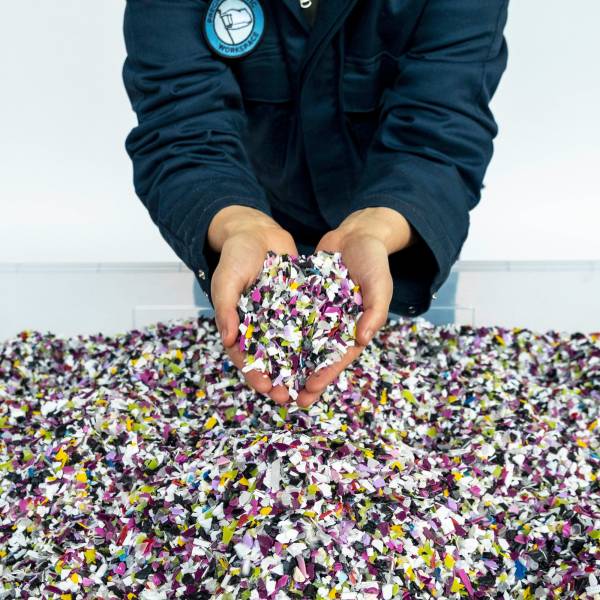 Colorful shredded plastic that is ready to be used to create material for Precious Plastic art pieces