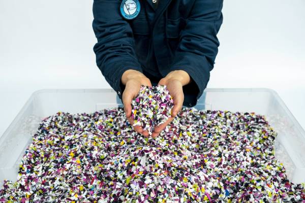 Colorful shredded plastic that is ready to be used to create material for Precious Plastic art pieces